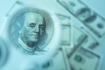Dollars. Magnifying glass over a hundred dollar bill. Concept - connections of economics states. Concept - search for counterfeit notes. Financial analytics. Economic forecast in the USA.