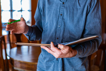 selective focus and close up shot of the inspector's hands as he holding a notebook and pen during...
