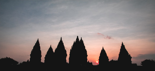 Obraz premium Prambanan or Candi Rara Jonggrang at sunset (low key). Hindu temple compound in Java, Indonesia, dedicated to the Trimurti: the Creator (Brahma), the Preserver (Vishnu) and the Destroyer (Shiva)