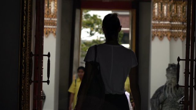 Woman sightseeing Buddhist temple in Bangkok, Thailand, slow motion