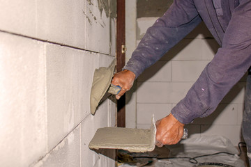 Close-up of a construction worker laying cement on the wall for building a house and building construction.