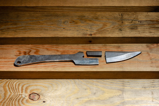 Broken throwing knife on a wooden background