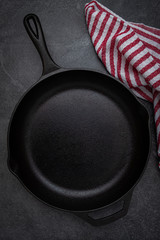 Cast Iron Skillet and Red and White Striped Dish Towel on Slate Countertop