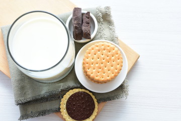 Chocolate cookies accompanied by glass of milk