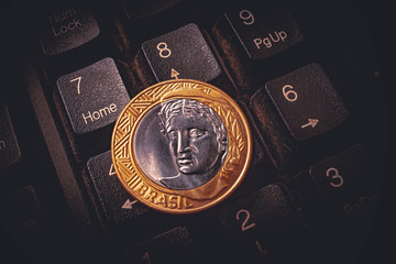 Moeda de 1 Real, Moeda brasileira. Foto ilustrativa tendo como cenário o teclado de um Pc Desktop...