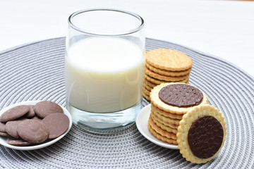 Chocolate cookies accompanied by glass of milk