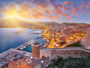 Amazing sunrise view from the walls of the citadel of Calvi, the old town with historic buildings....