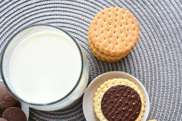 Chocolate cookies accompanied by glass of milk
