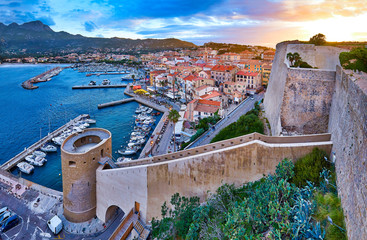 View from the walls of the citadel of Calvi on the old town with historic buildings at evening...