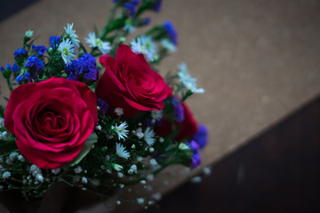 bouquet of roses arrangements of flowers in a paper wrapper on wooden background