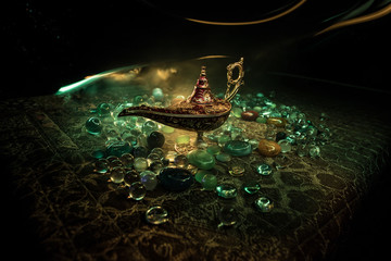 Lamp of wishes concept. Antique Aladdin arabian nights genie style oil lamp with soft light white...