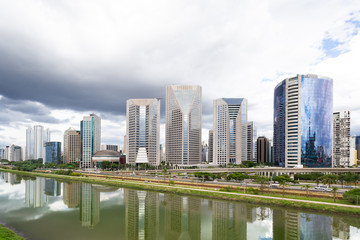 Fototapeta na wymiar Pinheiros river in Sao Paulo, Brazil, with modern buildings and their reflections in the water