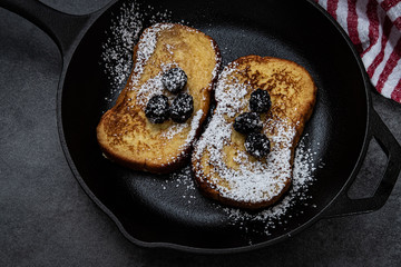 French toast for breakfast using brioche bread in a cast iron skillet