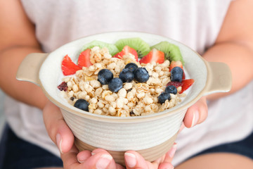 Hand of woman holding bowl of fresh strawberry and yogurt .Concept of healthy diet and weight control