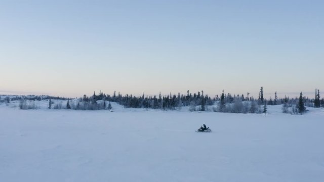 Aerial point of view of a male person riding a snowmobile