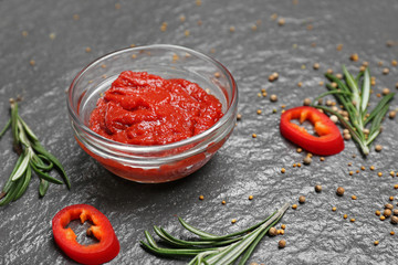 Bowl with tasty tomato sauce on dark background