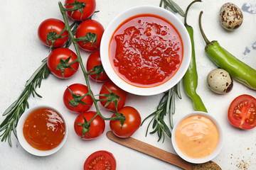 Different tasty sauces on white background