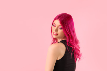 Beautiful young woman with unusual hair on color background