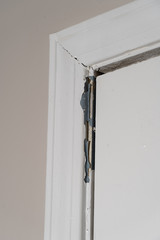 Cracked and peeling paint surround an interior door showing signs of wear and a need for repair.