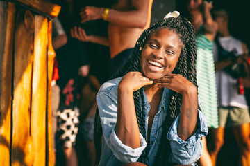 Charming beautiful young african american girl woman with black pigtails with piercings on her face sitting at a bar during a party - Powered by Adobe