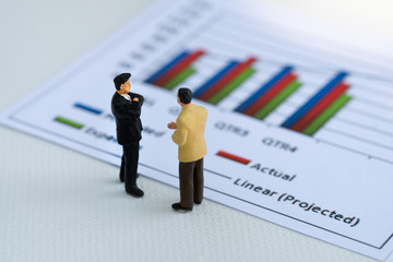 Miniature People: Business man looking at analyst graph with copy space using as background money, financial, business concept.
