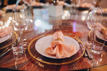 Wedding decorations. Festive table decorated with compositions of colored flowers. On the tables are plates, glasses, candles and cutlery