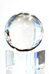 One glass ball on glass cube on white background