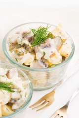 Salad rasols made of herring, cucumber and potato, dressed with mayonnaise and mustard