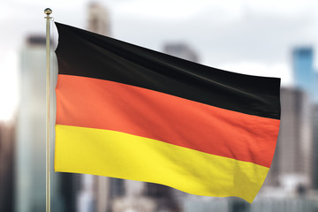 German flag waving on a blurry city background . Close Up