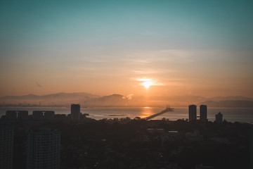 Obraz na płótnie Canvas Sunrise over the Penang bridge and buildings around it