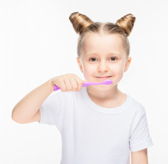 Little girl with a toothbrush in a white T-shirt on a white isolated background.