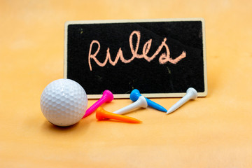 Golf rules with golf ball and tees are on orange background