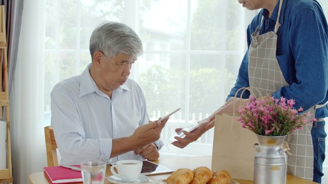 Senior man paying order with on QR Code by smartphone