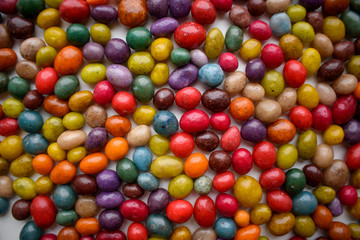 Fototapeta na wymiar Multi-colored candy stones for the background. Different sizes, uneven surface. Colors - red, blue, yellow, green. The concept of bright life, sweets.