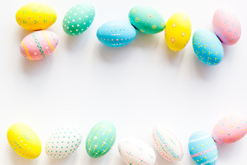 Colorful Easter eggs frame on white background top-down copy space