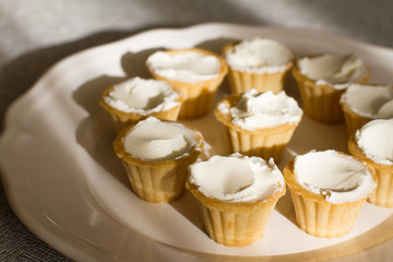 Tartlets with custard or cottage cheese. Empty tartlets or pie on a white table. Food lay flat. The view from the top. The concept of preparing food for the holiday table.