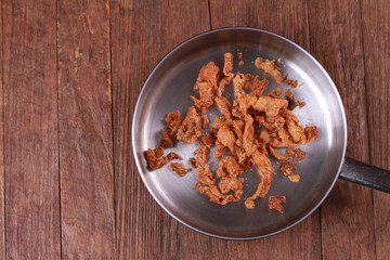 Fried chicken skin on wood table.