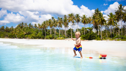 Kids play on tropical beach. Sand and water toy.