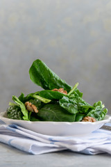 Close up view of raw spinach salad with walnuts