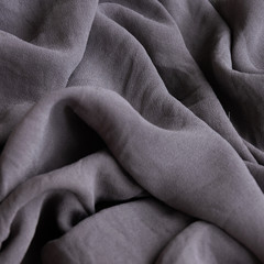Folded silk dark tone cloth. Crop view of fashioned ethnic fabric