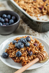Baked oatmeal with blueberries and honey in on white plate. Oatmeal fruit crumble pie.