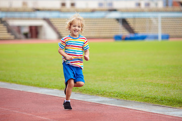 Child running in stadium. Kids run. Healthy sport.