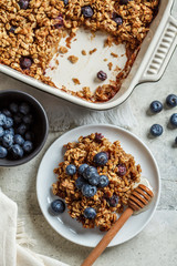 Baked oatmeal with blueberries and honey in on white plate, top view. Oatmeal fruit crumble pie.