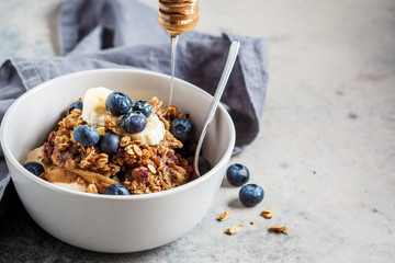 Homemade granola bowl with blueberries, banana and honey. - obrazy, fototapety, plakaty
