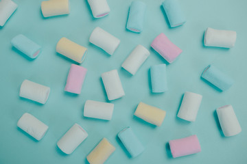 Fototapeta na wymiar Colorful marshmallow on blue background. Many candies on the table.