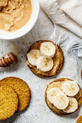 Crispbread with peanut butter, banana and honey, top view. Vegan food concept.