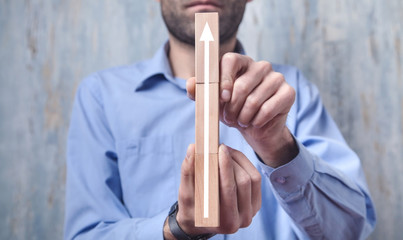 Man showing arrow on wooden blocks. Business, Growth, Success