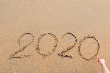 Abstract message Year 2020 written on beach sand