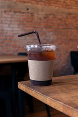 Close up of take away plastic cup of iced black coffee