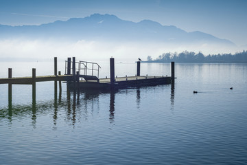 Steg am See und Berge im Nebel - Chiemsee im Winter